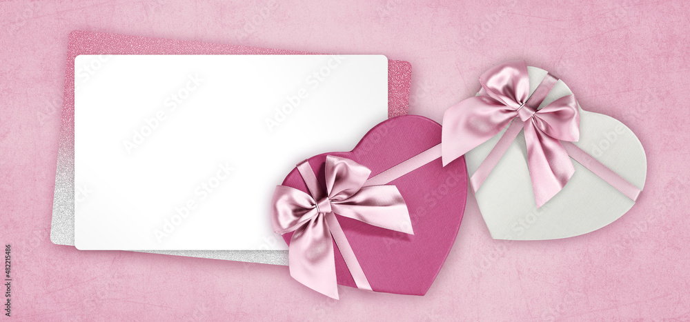 Mothers day gift card, heart shape boxes with pink shiny ribbon bow and blank white ticket with copy space isolated on pink background, top view and also for women's day or greetings card