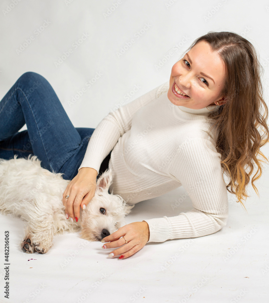 Attractive young european woman in warm white jumper isolated on white pet the dog Attractive young european woman in warm white jumper isolated on white pet the dog