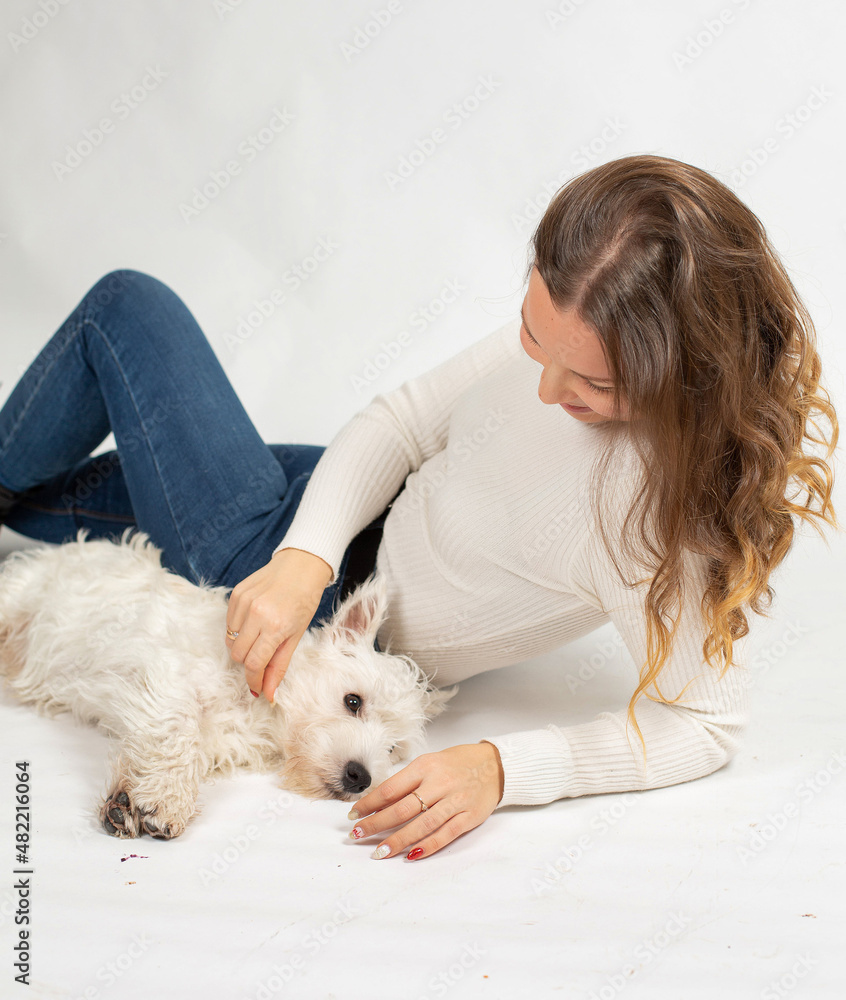 Attractive young european woman in warm white jumper isolated on white pet the dog Attractive young european woman in warm white jumper isolated on white pet the dog
