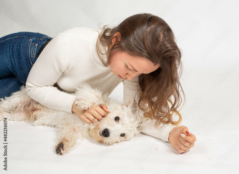 Lying attractive young european woman in warm white jumper with a dog isolated on white Lying attractive young european woman in warm white jumper with a dog isolated on white