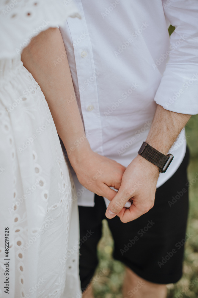 loving couple of newlyweds gently touches with hands, close-up