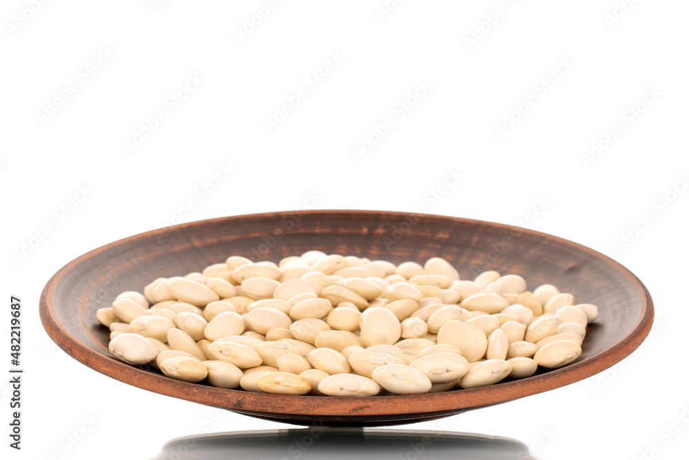 Lots of organic white beans on a clay dish, macro, isolated on white. Lots of organic white beans on a clay dish, macro, isolated on white.