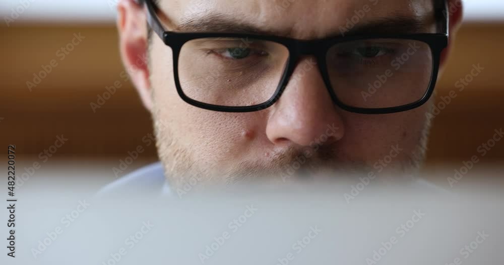 Close up view serious businessman in glasses sit in front of computer working looks at device screen. Workflow process use modern tech, eyesight check up, store ad of eyeglasses, lenses, frame concept Close up view serious businessman in glasses sit in front of computer working looks at device screen. Workflow process use modern tech, eyesight check up, store ad of eyeglasses, lenses, frame concept