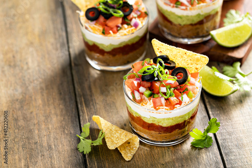 Seven layer dip in individual cups, mexican appetizer