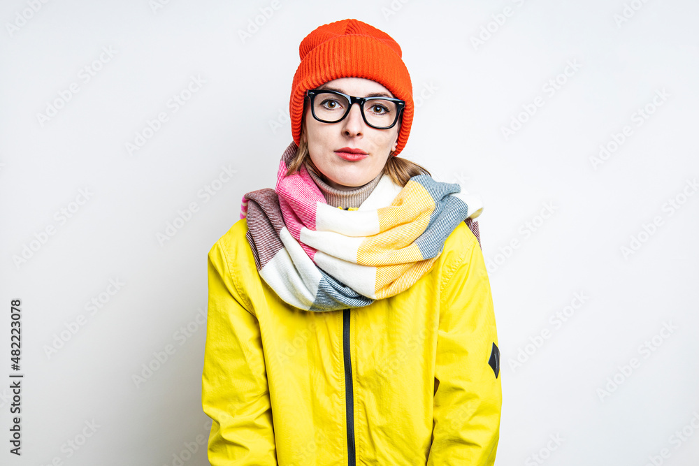 Sleepy young woman in glasses in a yellow jacket on a light background. Sleepy young woman in glasses in a yellow jacket on a light background.