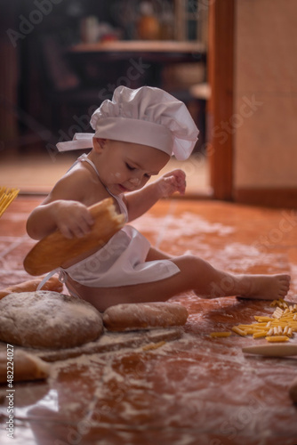 
child with bread in his hands dressed as a cook