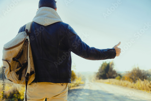 Cuadro en lienzo Man is hitchhiking on background of road