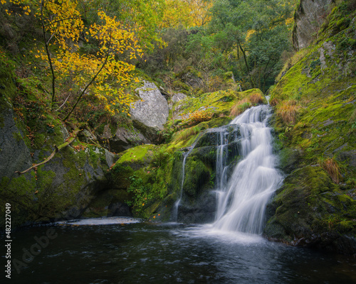 Small waterfall over a pool between granite rocks and autumn forest © Luis Vilanova