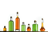 Several glass transparent bottles with cork stopper on a store shelf. Vintage glass bottles with colorful liquids on a white background.