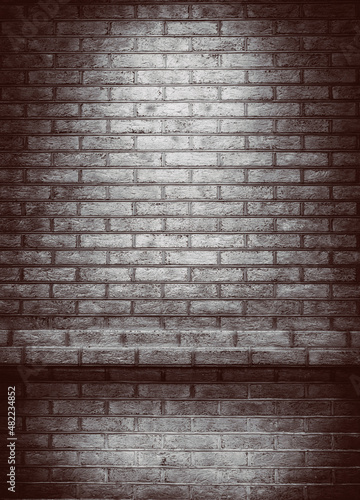 Empty space of Studio dark room black brick wall grunge texture background. Spotlight on a brick wall.