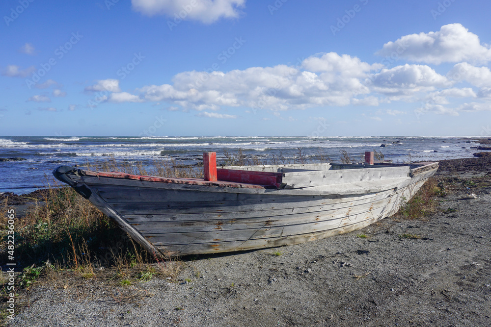 Wooden fishing boat on the shore by the sea