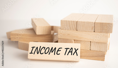 The INCOME TAX text is written on one of the many scattered wooden blocks