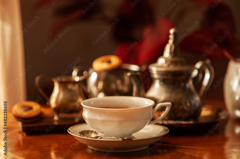 White porcelain cup and tea set. Still life in vintage style, selective focus, close-up White porcelain cup and tea set. Still life in vintage style, selective focus, close-up