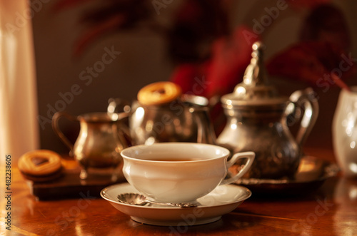 White porcelain cup and tea set. Still life in vintage style, selective focus, close-up