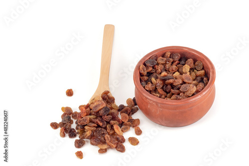 Raisins in a teaspoon. Raisins in a bowl isolated on a white background.