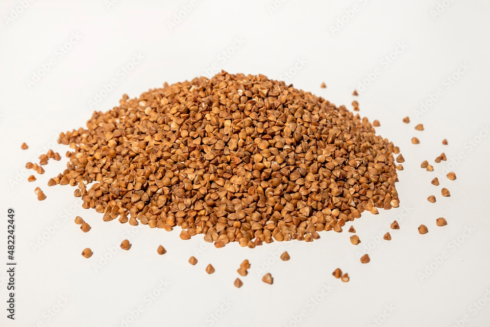 Buckwheat porridge. Mountain of buckwheat close up on a white background. Buckwheat porridge. Mountain of buckwheat close up on a white background.