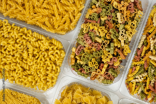 Close up of several types of dry pasta in a plate on white background photo