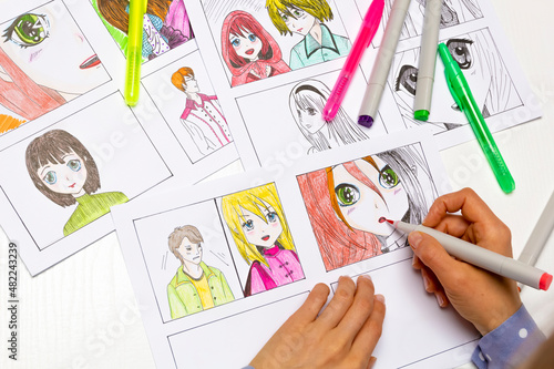 An artist draws a storyboard of an anime comics book. Manga style. The designer animator draws with a watercolor brush with a pen the characters of a color sketch of the cartoon.