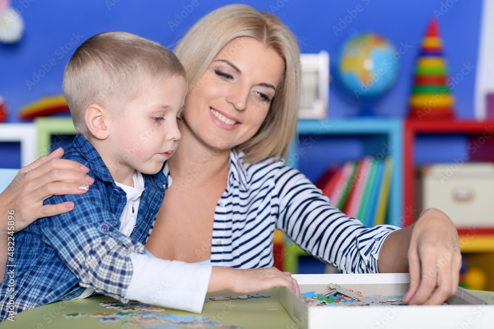 Portrait of mother and son collecting puzzle pieces Portrait of mother and son collecting puzzle pieces