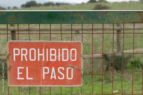 Señal de prohibido el paso en español, en una puerta de metal photo