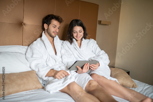 Couple in bed sharing a digital tablet