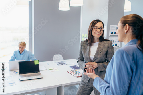 Foto Business women standing in the office and talking