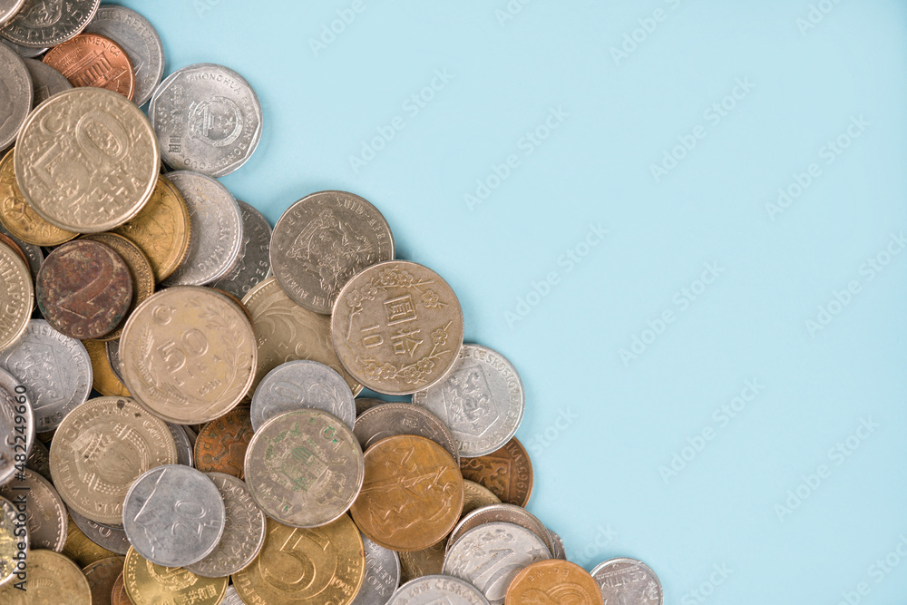 Variety of old coins on light blue background with copy space. Various vintage coins from worldwide as background. Financial growth and business concept. Numismatics and coin collecting Variety of old coins on light blue background with copy space. Various vintage coins from worldwide as background. Financial growth and business concept. Numismatics and coin collecting