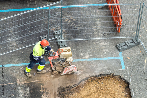 Photos obrero de la construcción cortando asfalto de una calle con una máquina cortador