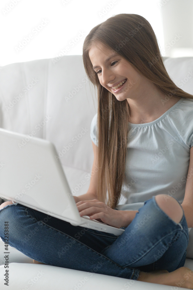 Cute girl with laptop on sofa at home Cute girl with laptop on sofa at home