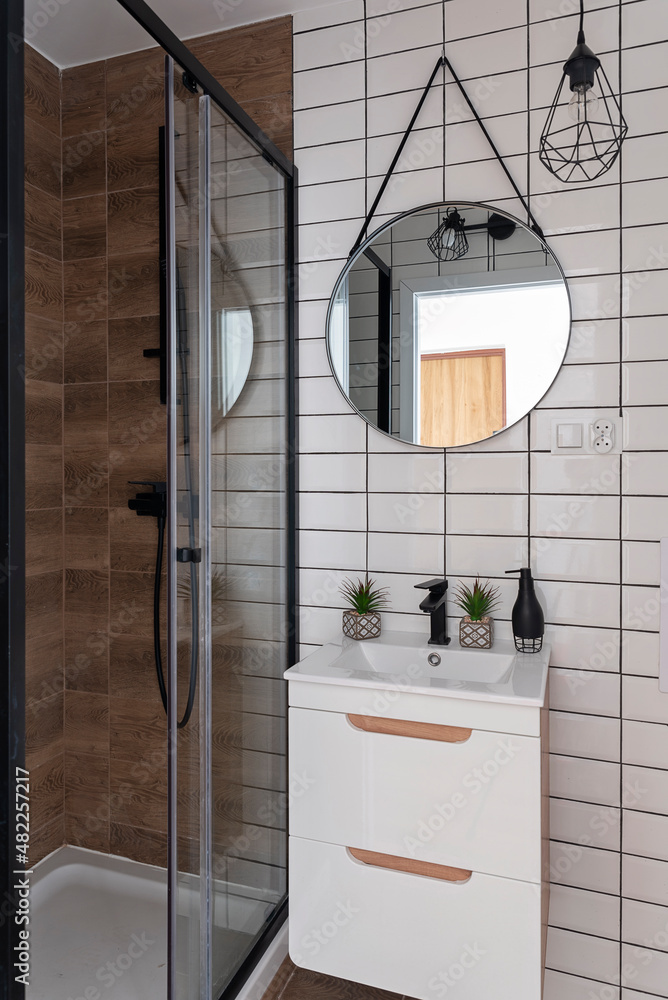 Interior of bathroom with stylish shower, bathroom cabinet with sink ...