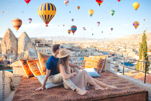 Obraz na płótnie Happy young couple during sunrise watching hot air balloons in Cappadocia, Turkey w salonie