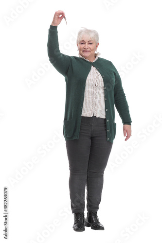 Close up head shot portrait happy older woman holding key from own apartment, looking at camera