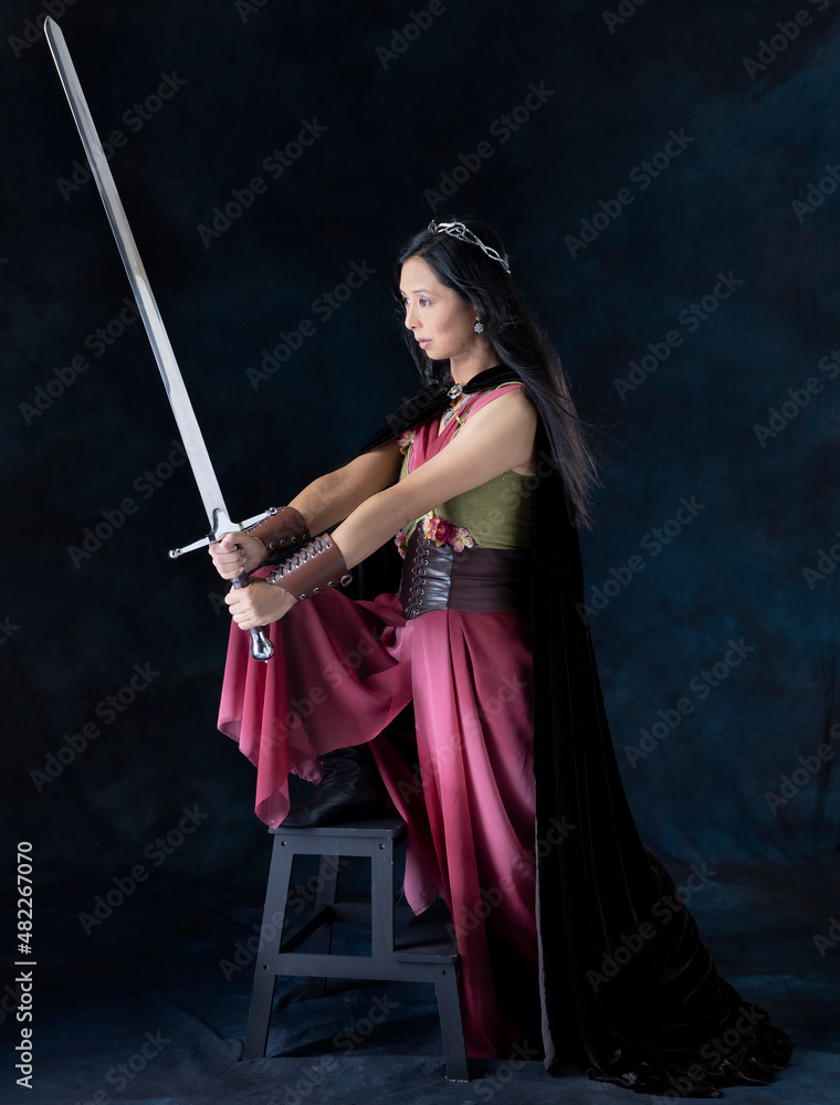 An elf warrior queen wearing a laced bodice and draped skirt and holding a sword An elf warrior queen wearing a laced bodice and draped skirt and holding a sword