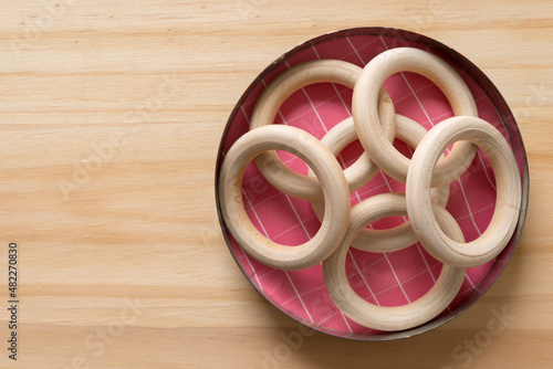 wooden rings in a metal container on a wooden surface