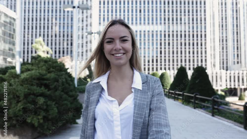 Front view of confident young businesswoman walking in financial district while looking at camera - Business people and entrepreneur concept. High quality 4k footage Front view of confident young businesswoman walking in financial district while looking at camera - Business people and entrepreneur concept. High quality 4k footage