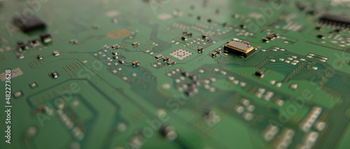 Components on a green circuit board. Close up, shallow depth of field background.