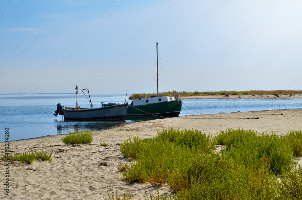 Boats are moored near the beach on the background of sea