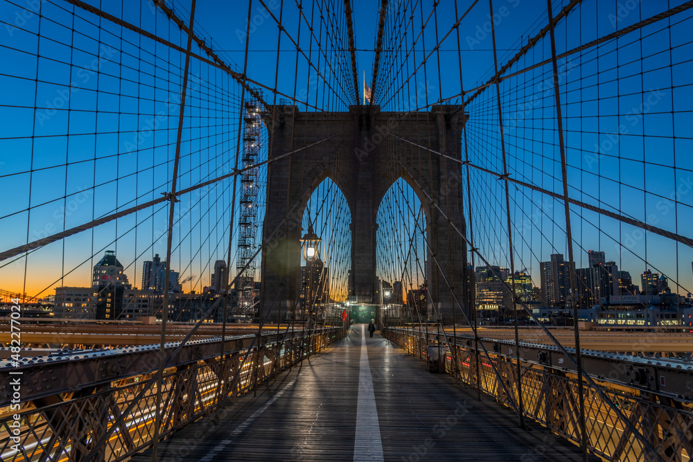 Fototapeta premium View of the Silhouette of the Brooklyn Bridge at Sunrise With Manhattan in the background