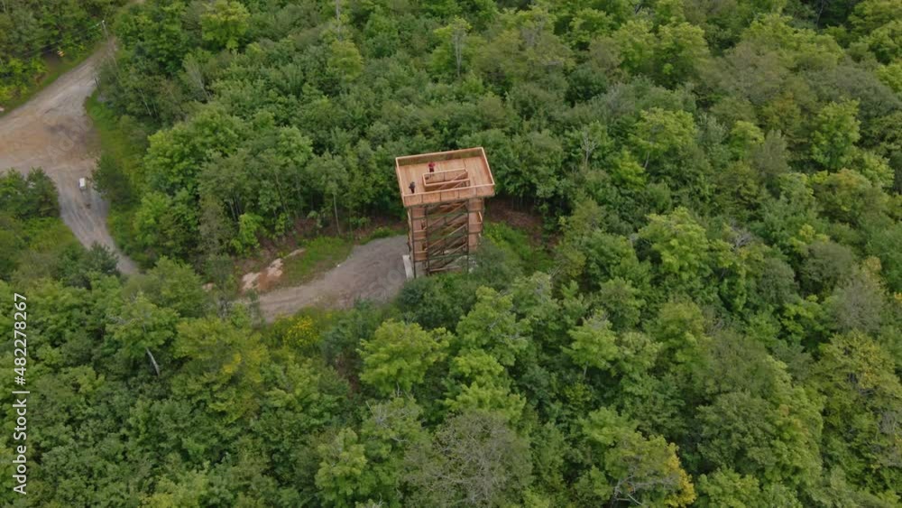 Aerial drone view showing the wooden watchtower in the middle of the park of Montagnes Noires in Outaouais Aerial drone view showing the wooden watchtower in the middle of the park of Montagnes Noires in Outaouais