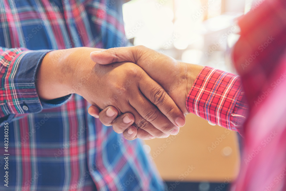 Fototapeta premium Team Business Partners shaking hands together to Greeting Start up small business in meeting room. Shakehand teamwork partners at modern office handshake together. Business mergers and acquisitions