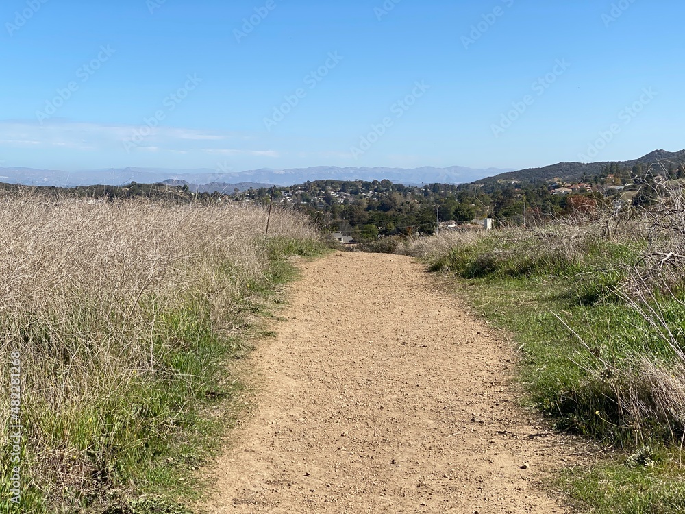 Path leading towards homes in Newbury Park,  CA, seen from nearby Point Mugu State Park. Typical Southern California suburb with mountains in background