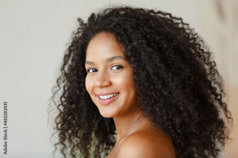 Portrait of an African American black woman. Beautiful woman at home. Girl with clean healthy skin. Lifestyle and cosmetics. Smiling beauty girl with afro curly hair Portrait of an African American black woman. Beautiful woman at home. Girl with clean healthy skin. Lifestyle and cosmetics. Smiling beauty girl with afro curly hair