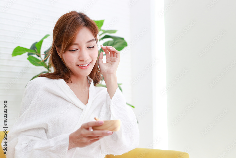 Beautiful Asian woman doing spa at home She holds a cup of natural honey to apply to her skin. beauty concept For good health, make the body comfortable, relaxed and beautiful. Beautiful Asian woman doing spa at home She holds a cup of natural honey to apply to her skin. beauty concept For good health, make the body comfortable, relaxed and beautiful.