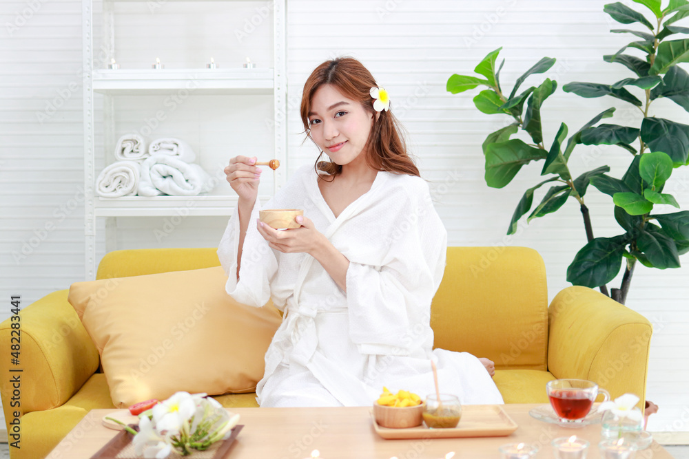 Beautiful Asian woman doing spa at home She holds a cup of natural honey to apply to her skin. beauty concept For good health, make the body comfortable, relaxed and beautiful. Beautiful Asian woman doing spa at home She holds a cup of natural honey to apply to her skin. beauty concept For good health, make the body comfortable, relaxed and beautiful.