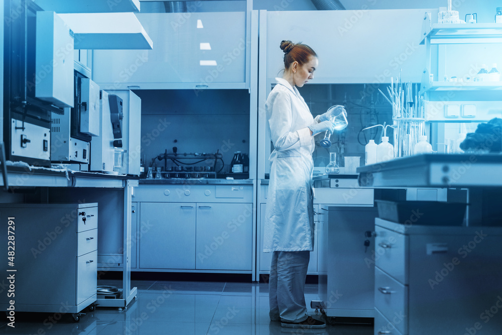 Naklejka premium Professional female scientist is working on a vaccine in a scientific research laboratory. Genetic engineer workplace. Technology and science concept. Stop COVID-19