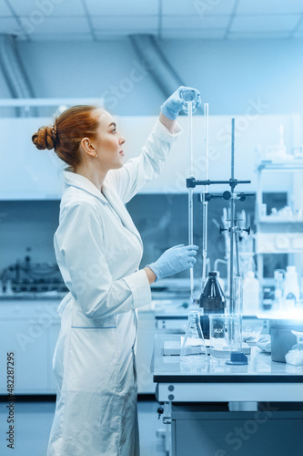 Professional female scientist is working on a vaccine in a scientific research laboratory. Genetic engineer workplace. Technology and science concept. Stop COVID-19