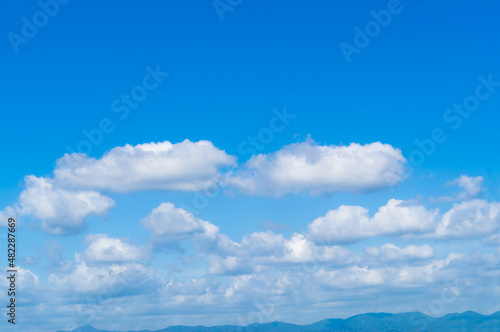 Beautiful blue sky background with clouds and green mountain, summer scenery in the upcountry