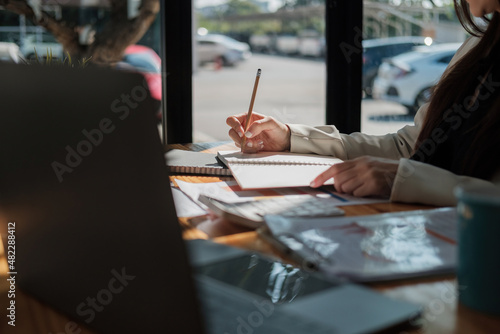 Woman hand taking notes on the notepad. Handwriting. Creative writing. business working for financial accounting calculation at offlice.