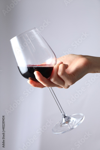 A woman holding a wine bottle and a wine glass.