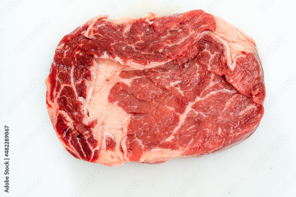 Close-up of one rib eye steak over white background. Aerial view